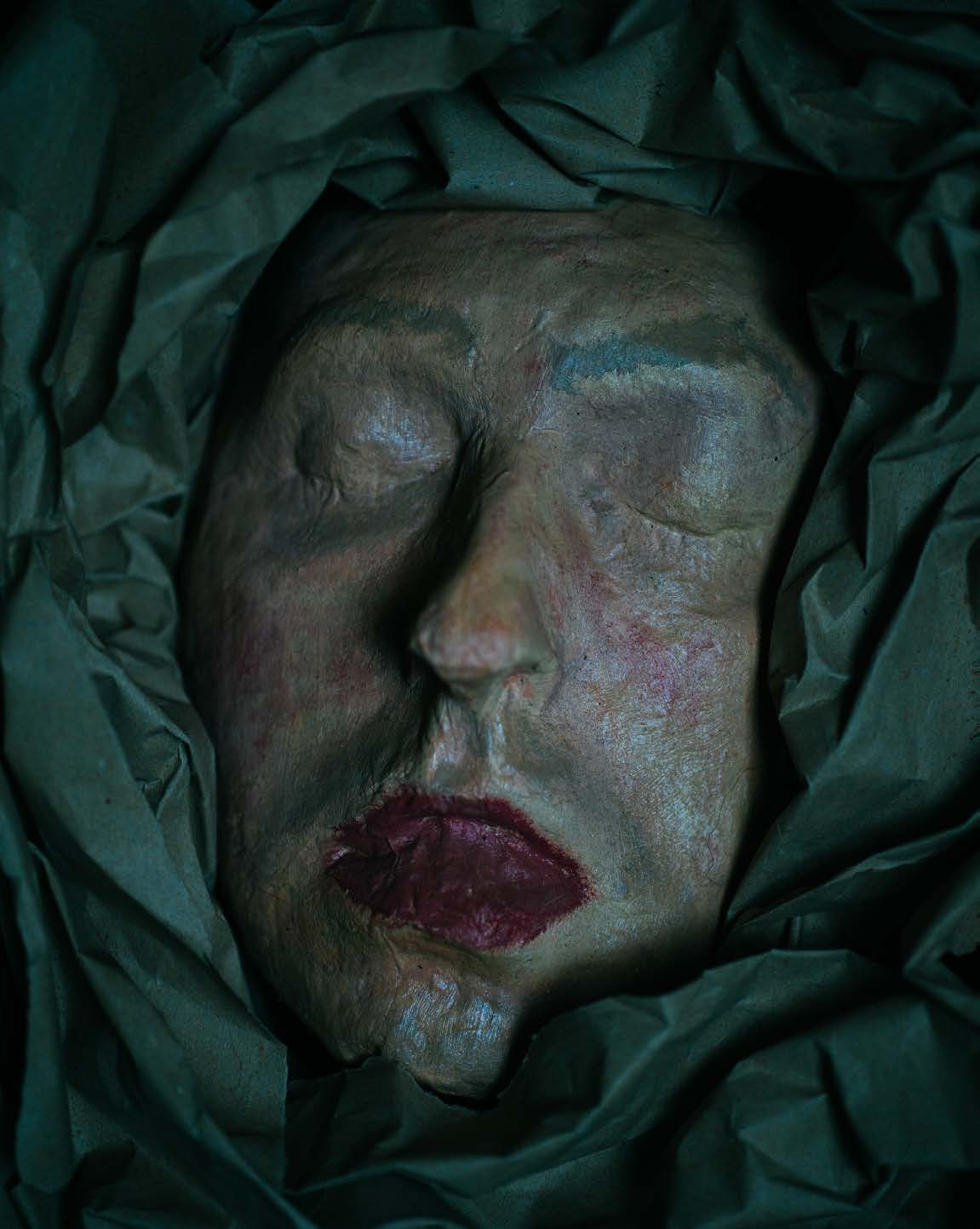 Masque peint entouré d’un tissu sombre